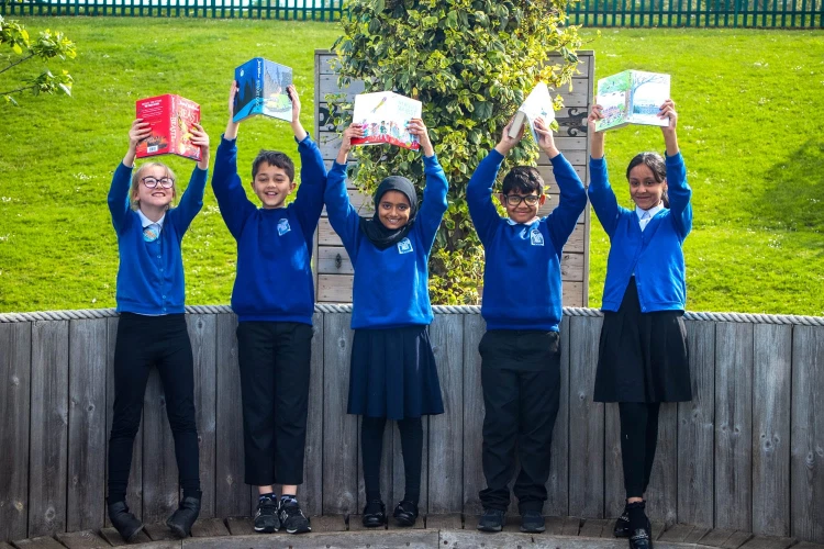 Children holding books in the air