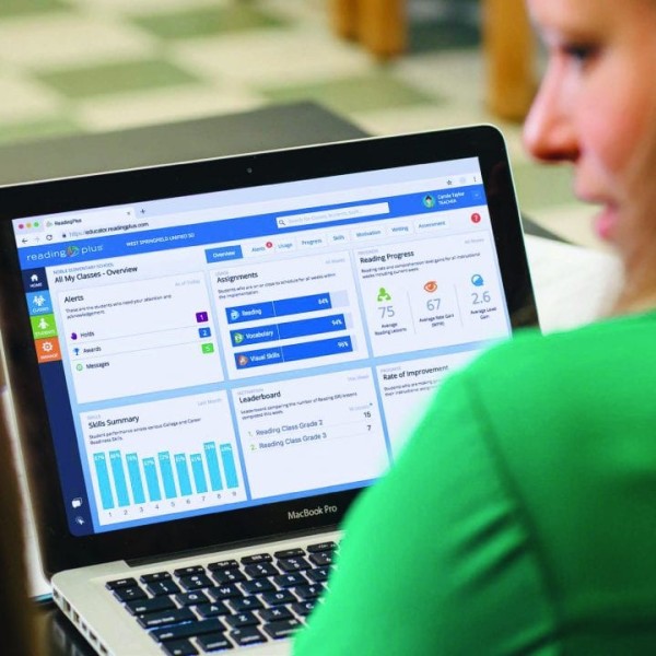 Person wearing a green top and using a laptop