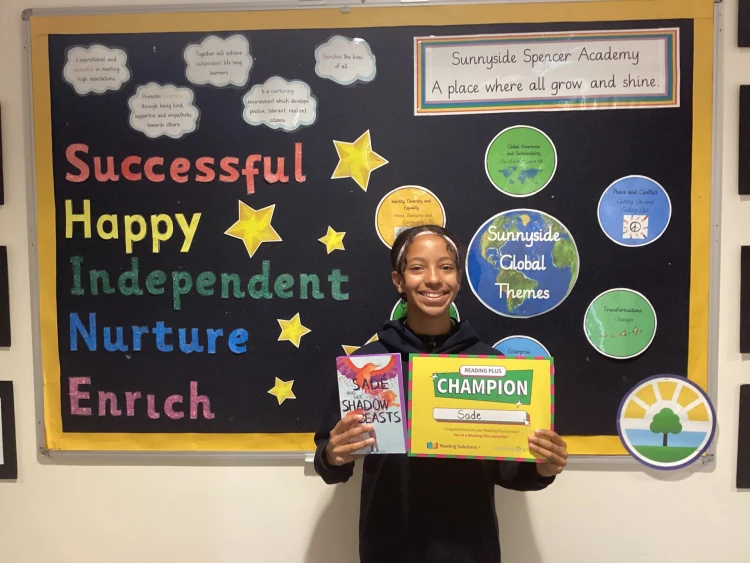 Child holding a Reading Plus Champions certificate 