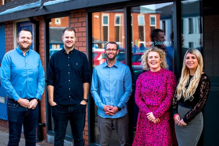 Five people standing in-front of the Daisy Education office